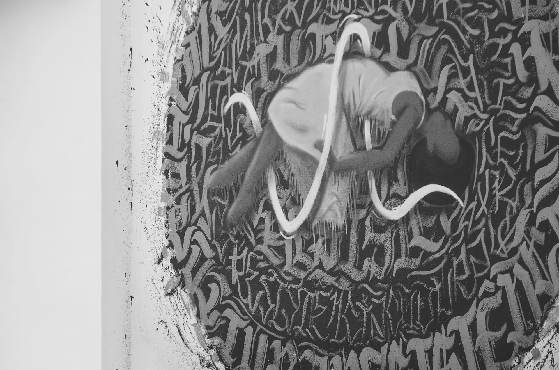 Grayscale photograph of a graffiti mural with a woman floating in the center